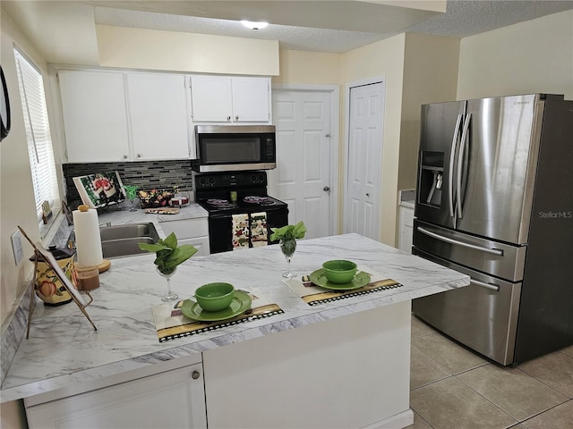 505 Innergary Pl, Valrico, FL 33594 - kitchen featuring stainless steel appliances, backsplash, a peninsula, white cabinetry, and light tile patterned floors