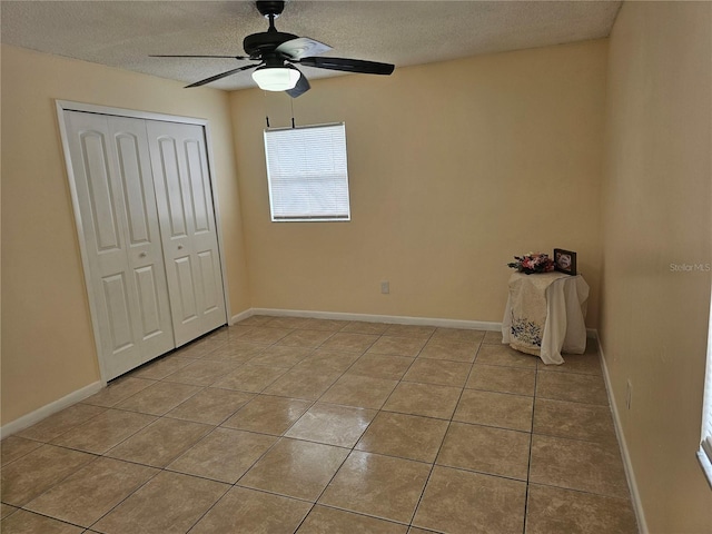 505 Innergary Pl, Valrico, FL 33594 - unfurnished bedroom featuring light tile patterned flooring, a textured ceiling, a closet, a ceiling fan, and baseboards