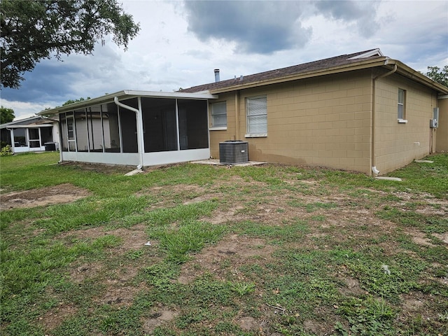 505 Innergary Pl, Valrico, FL 33594 - rear view of house featuring a sunroom, concrete block siding, a yard, and central AC unit