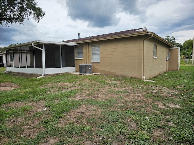 505 Innergary Pl, Valrico, FL 33594 - back of house featuring a sunroom, concrete block siding, cooling unit, and a yard