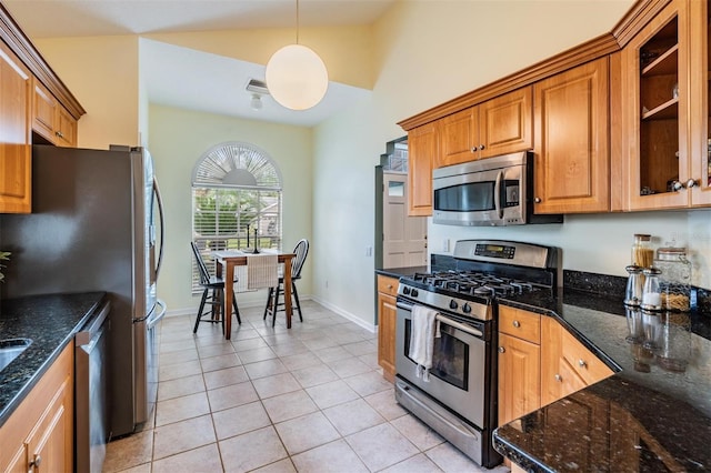 9806 Bennington Dr, Tampa, FL 33626 - kitchen with appliances with stainless steel finishes, vaulted ceiling, light tile patterned floors, brown cabinetry, and hanging light fixtures