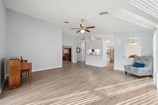 4411 Whitton Way, New Port Richey, FL 34653 - living room featuring lofted ceiling, a ceiling fan, wood finished floors, a chandelier, and baseboards