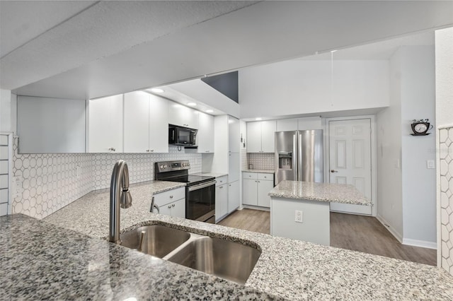 4411 Whitton Way, New Port Richey, FL 34653 - kitchen with stainless steel appliances, light wood finished floors, light stone countertops, decorative backsplash, and a sink