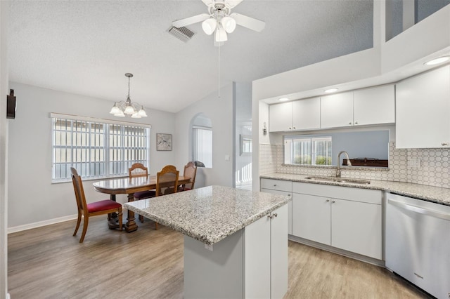 4411 Whitton Way, New Port Richey, FL 34653 - kitchen with dishwasher, a sink, vaulted ceiling, light wood-style floors, and backsplash