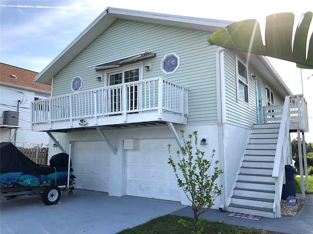 3312 Holly Springs Dr, Hernando Beach, FL 34607 - rear view of house with stairway, an attached garage, and driveway