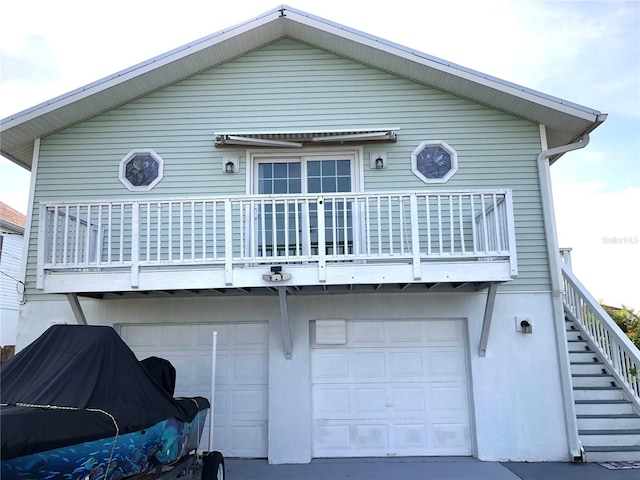 3312 Holly Springs Dr, Hernando Beach, FL 34607 - rear view of property featuring an attached garage, stairs, a balcony, and concrete driveway