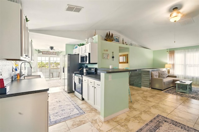 3312 Holly Springs Dr, Hernando Beach, FL 34607 - kitchen featuring appliances with stainless steel finishes, a sink, lofted ceiling, ceiling fan, and a kitchen breakfast bar