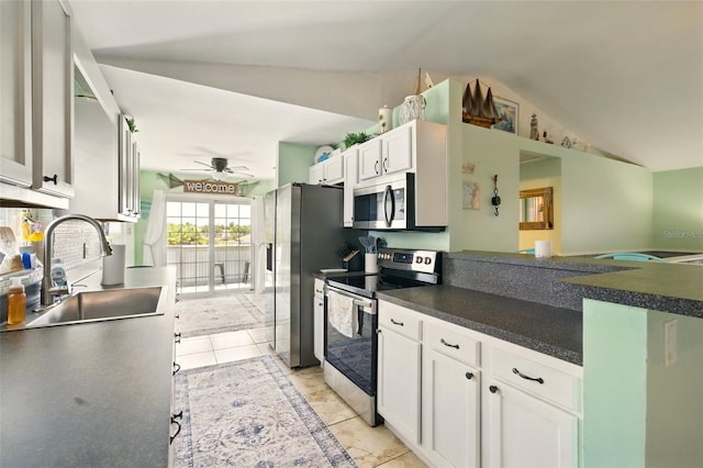 3312 Holly Springs Dr, Hernando Beach, FL 34607 - kitchen with stainless steel appliances, a sink, lofted ceiling, white cabinets, and a ceiling fan