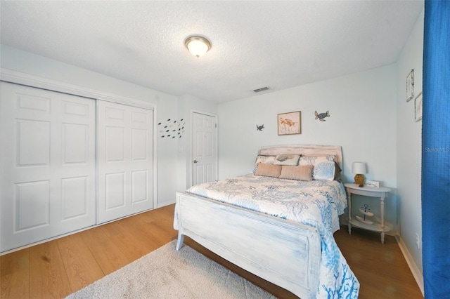 3312 Holly Springs Dr, Hernando Beach, FL 34607 - bedroom featuring wood finished floors, a closet, and a textured ceiling