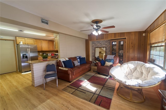 18121 Geraci Rd, Lutz, FL 33548 - living room with ceiling fan, light wood-type flooring, and wooden walls