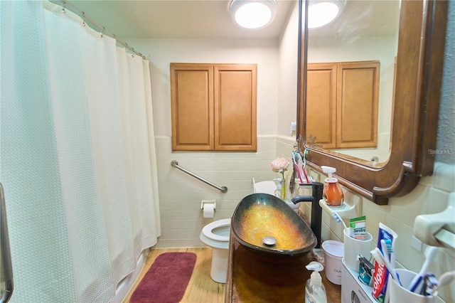 18121 Geraci Rd, Lutz, FL 33548 - full bathroom with tile walls, a sink, toilet, wood finished floors, and a shower with shower curtain
