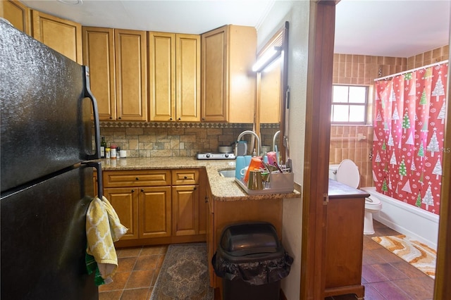 18121 Geraci Rd, Lutz, FL 33548 - kitchen featuring freestanding refrigerator, dark tile patterned floors, brown cabinetry, and a sink