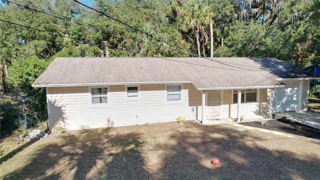 1585 W J Williams Ln, Dunnellon, FL 34434 - ranch-style house with covered porch, roof with shingles, brick siding, and a view of trees