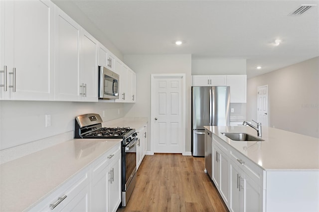 1221 Tidal St, Haines City, FL 33844 - kitchen with stainless steel appliances, a sink, recessed lighting, light countertops, and light wood-type flooring