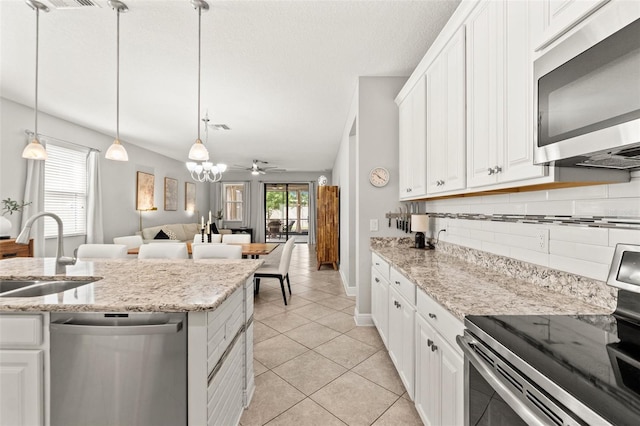 18620 Rococo Rd, Spring Hill, FL 34610 - kitchen featuring stainless steel appliances, a sink, backsplash, light tile patterned flooring, and white cabinets