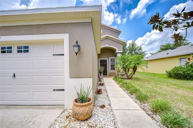 4227 Bethpage Ct, Wesley Chapel, FL 33543 - property entrance featuring stucco siding, an attached garage, and a yard