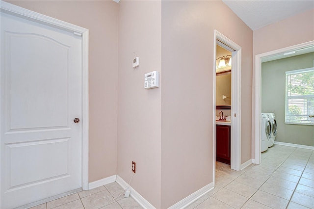 4227 Bethpage Ct, Wesley Chapel, FL 33543 - hall featuring independent washer and dryer, light tile patterned floors, baseboards, and a sink