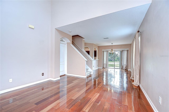 4227 Bethpage Ct, Wesley Chapel, FL 33543 - foyer entrance with wood finished floors, arched walkways, stairs, and baseboards