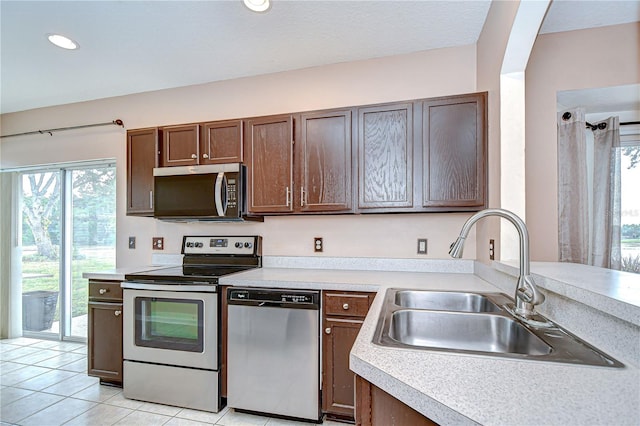 4227 Bethpage Ct, Wesley Chapel, FL 33543 - kitchen with appliances with stainless steel finishes, a sink, light countertops, light tile patterned floors, and recessed lighting