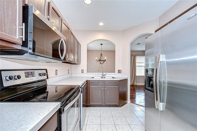 4227 Bethpage Ct, Wesley Chapel, FL 33543 - kitchen with stainless steel appliances, a sink, light countertops, light tile patterned floors, and a textured ceiling