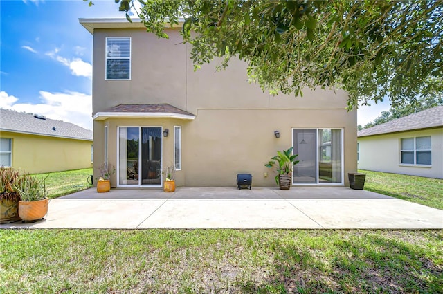 4227 Bethpage Ct, Wesley Chapel, FL 33543 - back of house with stucco siding, a yard, and a patio