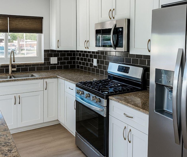 5264 S Spy Glass Pt, Homosassa, FL 34448 - kitchen with stainless steel appliances, dark countertops, backsplash, and white cabinetry