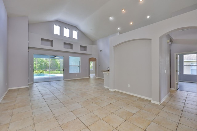 7114 Cromwell Park Ln, Apollo Beach, FL 33572 - empty room with lofted ceiling, healthy amount of natural light, light tile patterned floors, ceiling fan, and recessed lighting