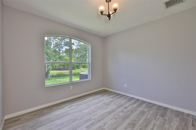 7114 Cromwell Park Ln, Apollo Beach, FL 33572 - unfurnished room featuring a chandelier, light wood-type flooring, healthy amount of natural light, and baseboards