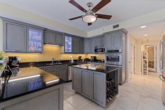 1 Beach Dr SE Unit 2011, Saint Petersburg, FL 33701 - kitchen featuring appliances with stainless steel finishes, a sink, dark countertops, tasteful backsplash, and a ceiling fan