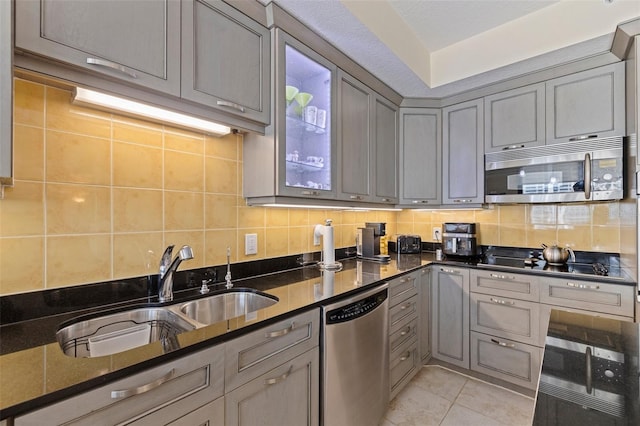 1 Beach Dr SE Unit 2011, Saint Petersburg, FL 33701 - kitchen featuring stainless steel appliances, gray cabinetry, decorative backsplash, a sink, and glass insert cabinets