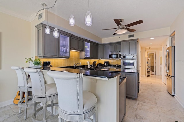 1 Beach Dr SE Unit 2011, Saint Petersburg, FL 33701 - kitchen featuring appliances with stainless steel finishes, dark countertops, a peninsula, a breakfast bar area, and baseboards