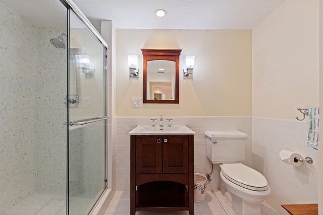 1 Beach Dr SE Unit 2011, Saint Petersburg, FL 33701 - full bathroom with a shower stall, toilet, tile walls, vanity, and wainscoting