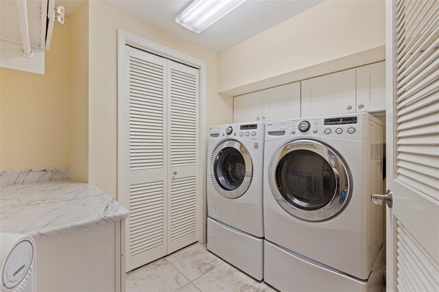 1 Beach Dr SE Unit 2011, Saint Petersburg, FL 33701 - washroom featuring cabinet space, independent washer and dryer, and light tile patterned flooring