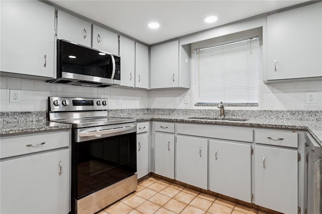 7503 Winchester Dr, Tampa, FL 33615 - kitchen with appliances with stainless steel finishes, a sink, backsplash, light stone countertops, and light tile patterned floors