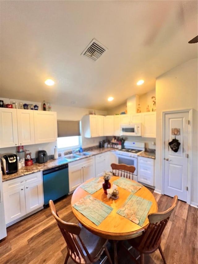 5351 Leisure Ln, New Port Richey, FL 34652 - kitchen featuring white appliances, white cabinets, wood finished floors, a sink, and recessed lighting