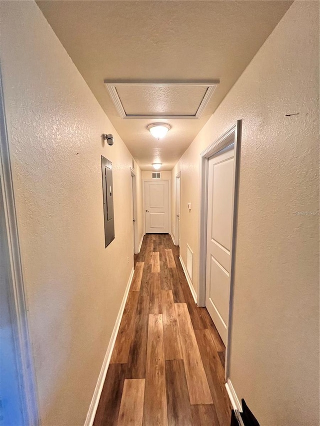 5351 Leisure Ln, New Port Richey, FL 34652 - corridor featuring wood finished floors, a textured wall, and baseboards