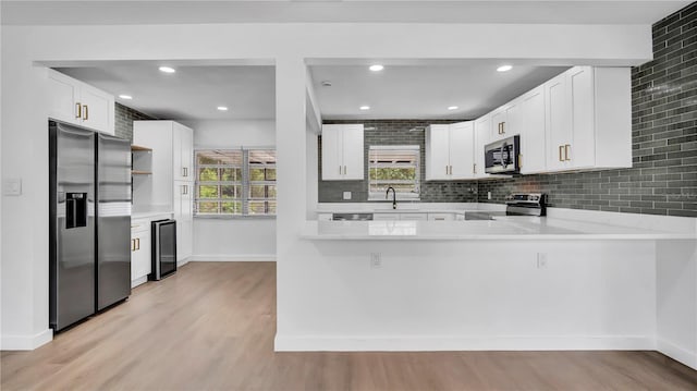 603 Amana Ave, Brandon, FL 33510 - kitchen featuring appliances with stainless steel finishes, a sink, light wood-style floors, a peninsula, and recessed lighting