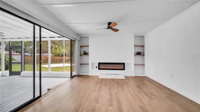 603 Amana Ave, Brandon, FL 33510 - unfurnished living room with ceiling fan, a glass covered fireplace, built in shelves, and wood finished floors