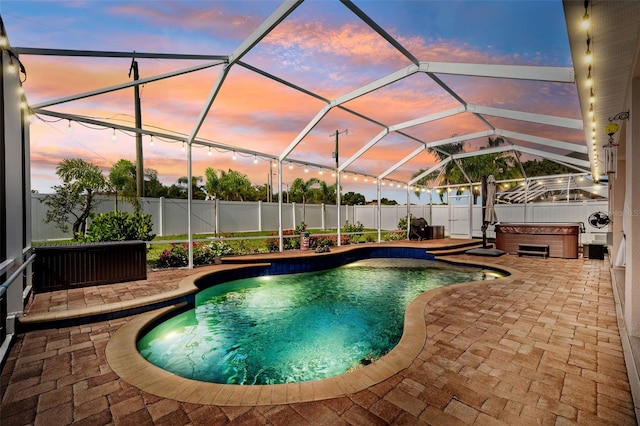 2814 Duncan Tree Cir, Valrico, FL 33594 - pool at dusk featuring a hot tub, a patio, a fenced backyard, and a lanai