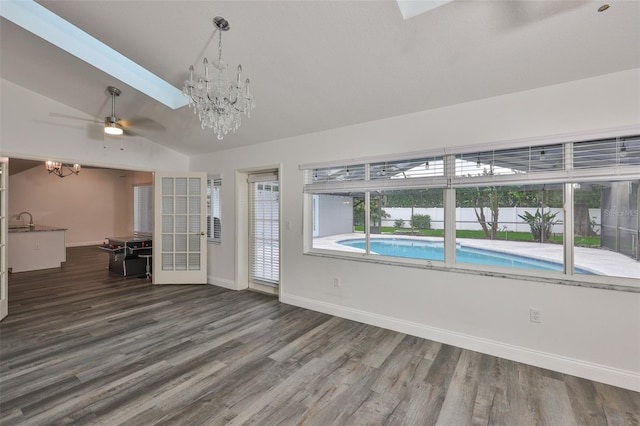 1034 Brighton Way, Lakeland, FL 33813 - unfurnished living room featuring a chandelier, a ceiling fan, baseboards, dark wood finished floors, and lofted ceiling