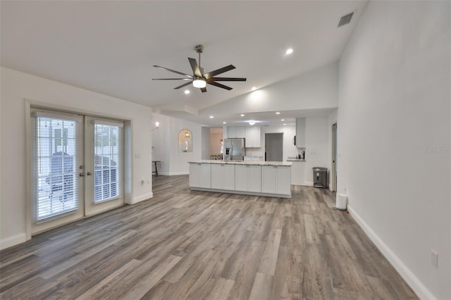 1034 Brighton Way, Lakeland, FL 33813 - unfurnished living room with french doors, vaulted ceiling, a ceiling fan, light wood-type flooring, and recessed lighting