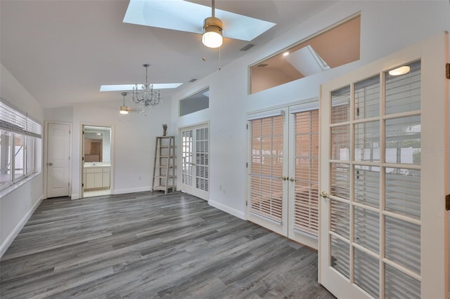 1034 Brighton Way, Lakeland, FL 33813 - unfurnished living room with a skylight, wood finished floors, lofted ceiling, baseboards, and a chandelier