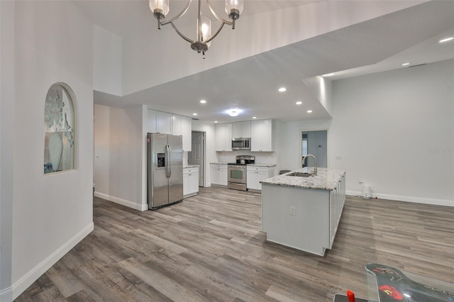 1034 Brighton Way, Lakeland, FL 33813 - kitchen featuring appliances with stainless steel finishes, a sink, baseboards, white cabinetry, and a high ceiling