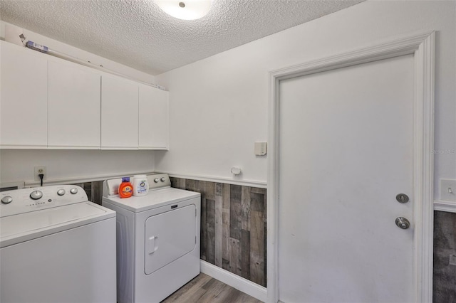 1034 Brighton Way, Lakeland, FL 33813 - washroom with cabinet space, washing machine and dryer, wainscoting, light wood finished floors, and a textured ceiling