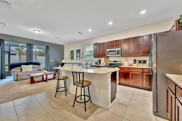 3320 Pleasant Willow Ct, Brandon, FL 33511 - kitchen with stainless steel appliances, open floor plan, a sink, a kitchen breakfast bar, and plenty of natural light