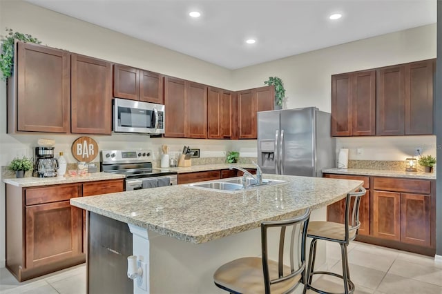 3320 Pleasant Willow Ct, Brandon, FL 33511 - kitchen with stainless steel appliances, a sink, light tile patterned floors, a breakfast bar, and an island with sink
