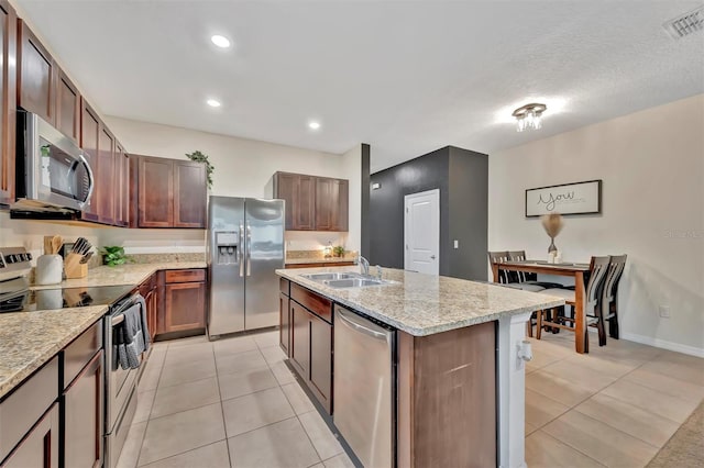 3320 Pleasant Willow Ct, Brandon, FL 33511 - kitchen featuring appliances with stainless steel finishes, light tile patterned flooring, a sink, a center island with sink, and recessed lighting