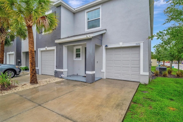 3320 Pleasant Willow Ct, Brandon, FL 33511 - multi unit property featuring stucco siding, a garage, concrete driveway, central air condition unit, and a front lawn