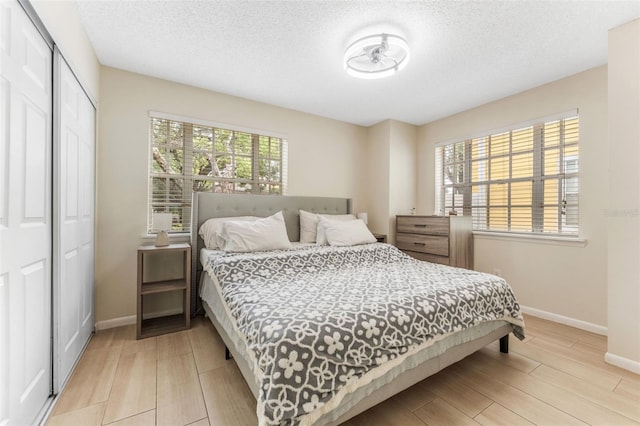 3002 W Cleveland St Unit D4, Tampa, FL 33609 - bedroom with light wood finished floors, baseboards, a closet, and a textured ceiling