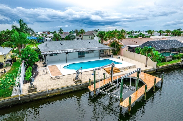 913 Spindle Palm Way, Apollo Beach, FL 33572 - back of house featuring boat lift, a water view, a patio area, a residential view, and a fenced backyard